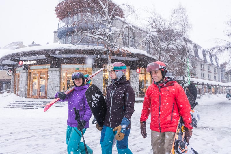 Skiers in falling snow in the village